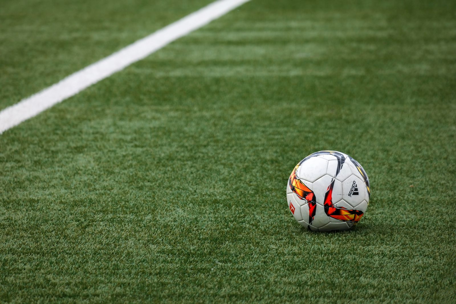 Football resting on the pitch line